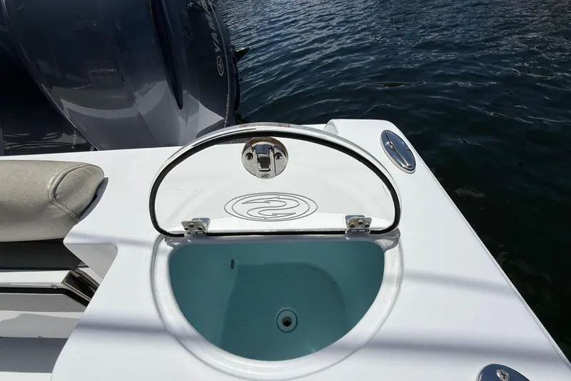 Slide: The Image of 2021 Sportsman Open 252 Center Console boat with open livewell by the water. - 7