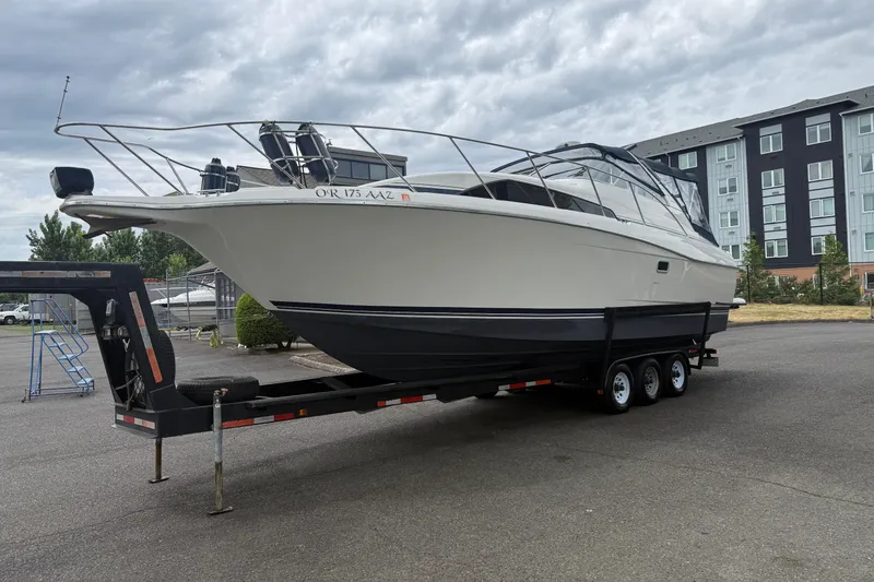 Slide: The Image of 1997 Bayliner 3255 Avanti boat on trailer, parked outdoors near buildings. - 1