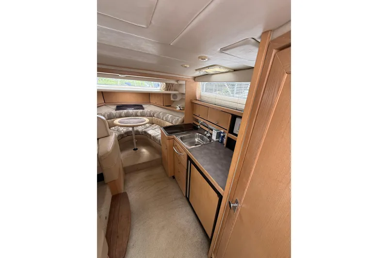 Slide: The Image of Interior of 1997 Bayliner 3255 Avanti boat with kitchenette and seating area. - 11