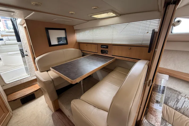 Slide: The Image of Interior of 1997 Bayliner 3255 Avanti boat with beige seating and wooden table. - 13