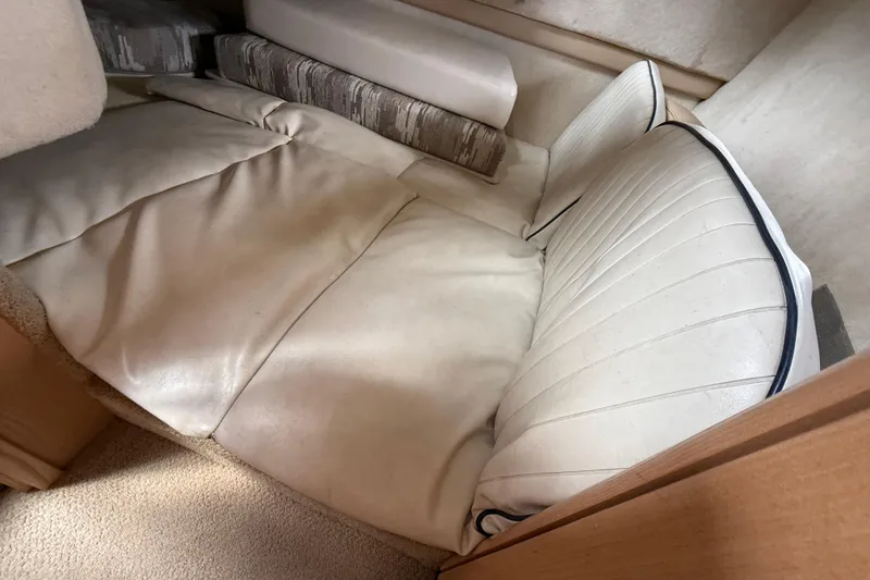 Slide: The Image of 1997 Bayliner 3255 Avanti cabin interior with cushioned seating and beige upholstery. - 16