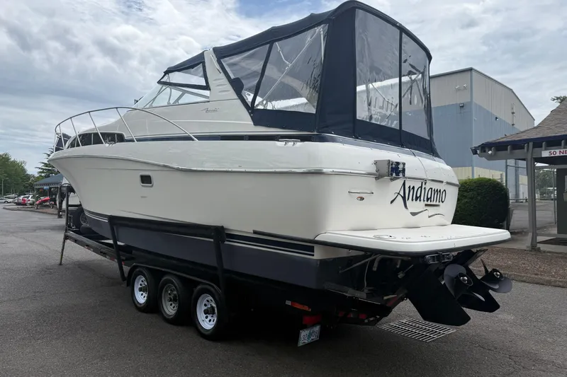 Slide: The Image of 1997 Bayliner 3255 Avanti boat on trailer, featuring sleek design and covered cockpit. - 2