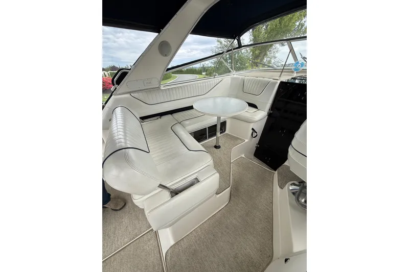 Slide: The Image of Interior of a 1997 Bayliner 3255 Avanti boat with white seating and table. - 26