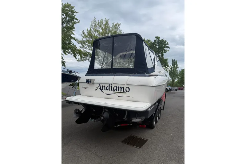 Slide: The Image of 1997 Bayliner 3255 Avanti boat on trailer, rear view with cover, parked outdoors. - 3