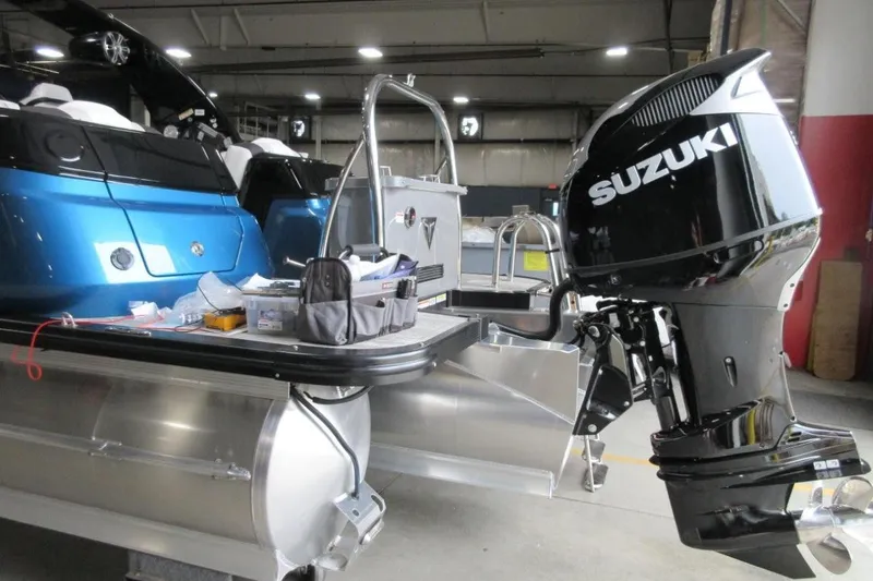 Slide: The Image of 2026 Tahoe boat with Suzuki outboard motor in a workshop setting. - 5