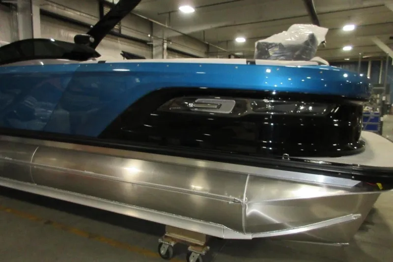 Slide: The Image of 2026 Tahoe boat with sleek blue and black design in a warehouse setting. - 7