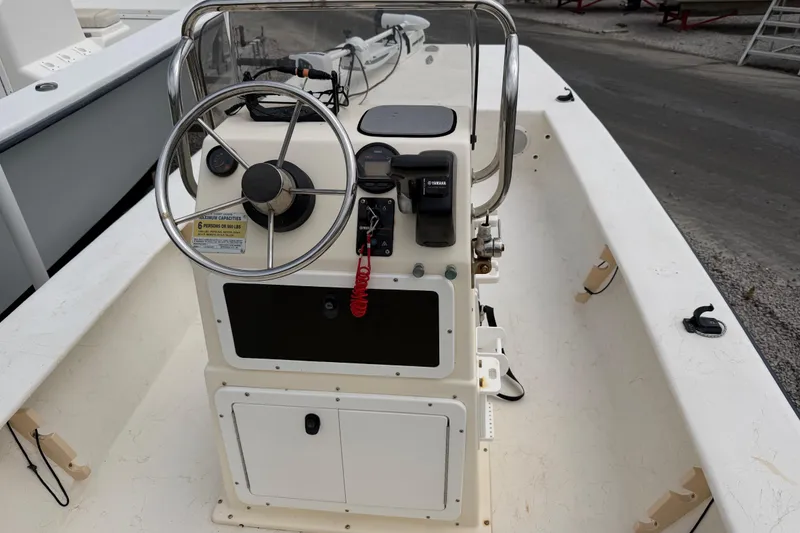 Slide: The Image of Center console of a 2006 Jones Brothers Bateau 17 boat, featuring steering wheel and controls. - 12
