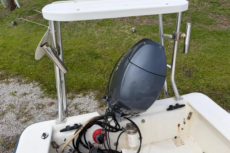 Slide: The Image of 2006 Jones Brothers Bateau 17 boat with outboard motor, parked on grassy area. - 15