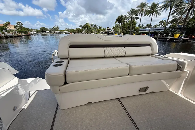 Slide: The Image of Luxury seating on 2022 Regal 33 XO boat, docked by palm-lined waterfront. - 10