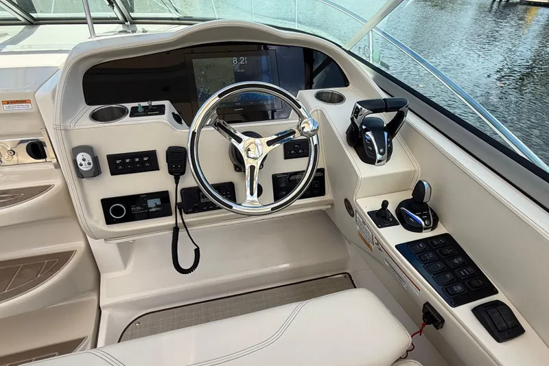 Slide: The Image of Cockpit of 2022 Regal 33 XO boat with modern controls and steering wheel. - 17