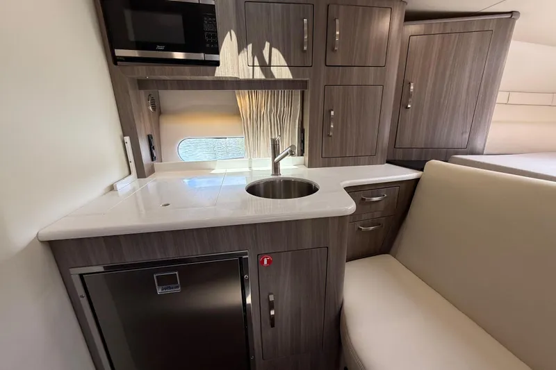 Slide: The Image of Modern kitchen area in 2022 Regal 33 XO yacht with sleek cabinetry and compact design. - 20