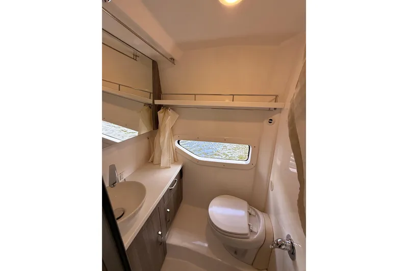 Slide: The Image of 2022 Regal 33 XO boat bathroom with sink, toilet, and window. - 23