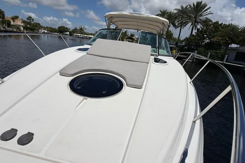 Slide: The Image of 2022 Regal 33 XO boat with sunpad, docked on a sunny day, surrounded by palm trees. - 25