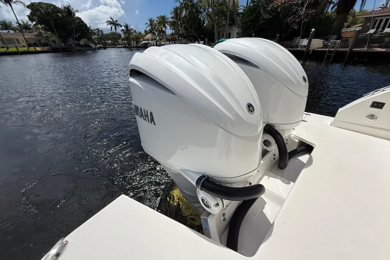 Slide: The Image of Twin Yamaha outboard engines on a 2022 Regal 33 XO boat, docked by a scenic waterfront. - 6