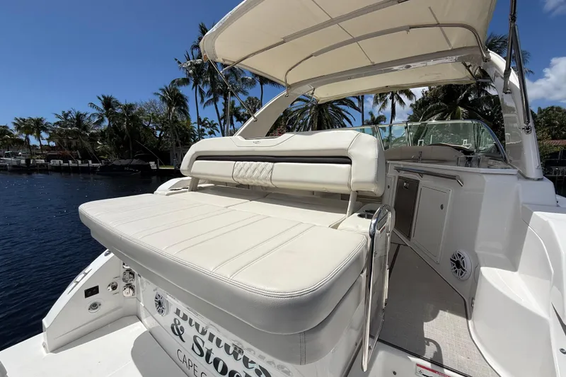 Slide: The Image of 2022 Regal 33 XO yacht with seating area, docked near palm trees. - 8