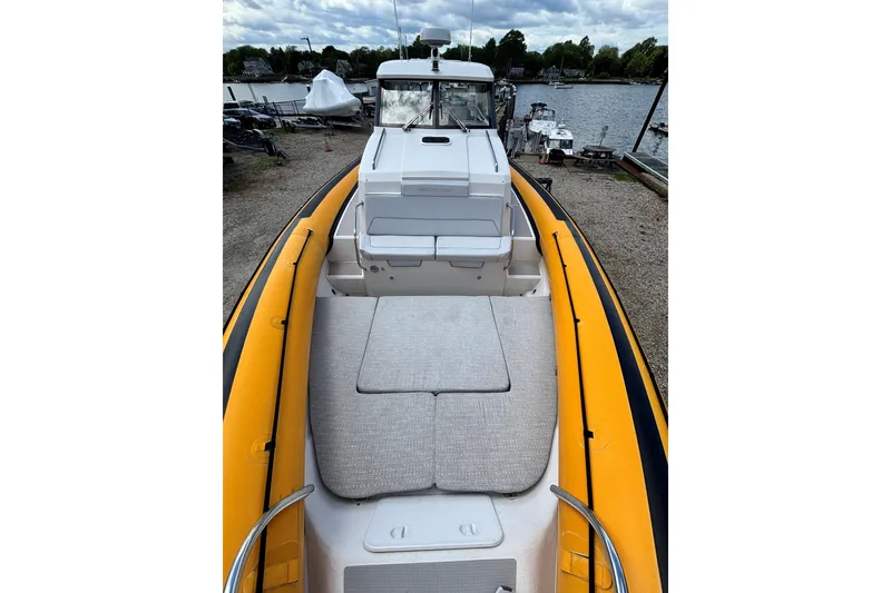 Slide: The Image of 2020 Protector 380 Targa boat with yellow inflatable sides docked by a lake. - 11