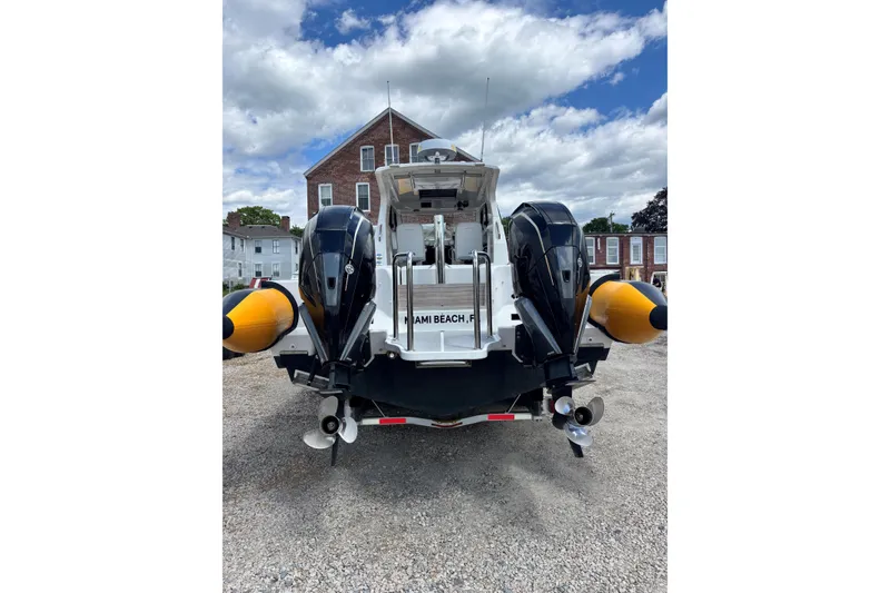 Slide: The Image of Rear view of 2020 Protector 380 Targa boat with dual engines, parked on gravel. - 16