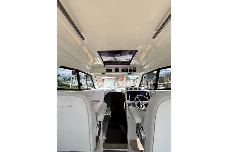 Slide: The Image of Interior view of 2020 Protector 380 Targa boat, featuring helm and seating area. - 21