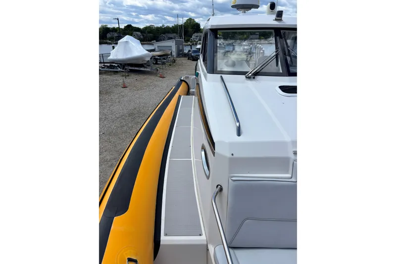 Slide: The Image of 2020 Protector 380 Targa boat docked, showcasing sleek design and vibrant yellow accents. - 8
