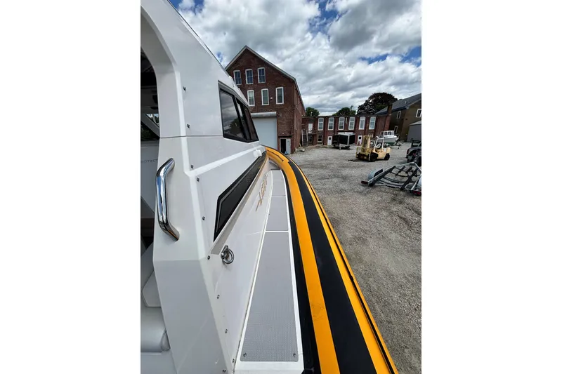 Slide: The Image of 2020 Protector 380 Targa boat docked near brick buildings under cloudy sky. - 9