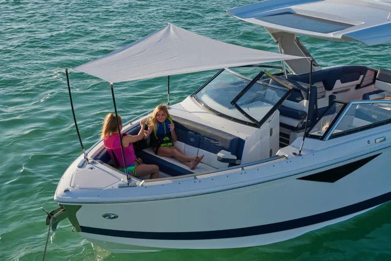 Slide: The Image of Manufacturer Provided Image: 2025 Cobalt A29 boat with sunshade, two people relaxing on calm water. - 5