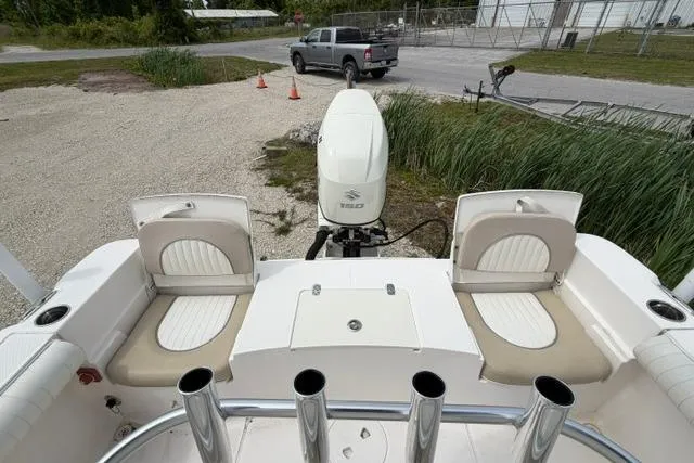 Slide: The Image of 2019 Sea Born LX21 Center Console boat with seating and outboard motor, parked on gravel. - 14