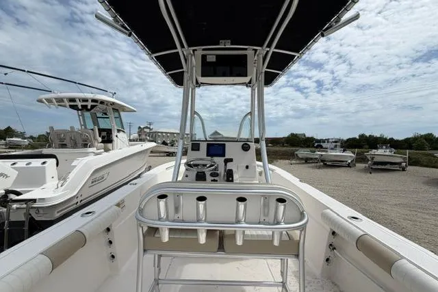 Slide: The Image of 2019 Sea Born LX21 Center Console boat with T-top and rod holders, docked under cloudy skies. - 18