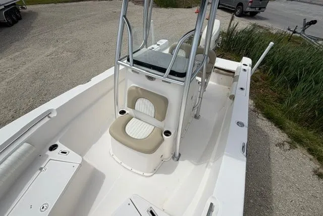 Slide: The Image of 2019 Sea Born LX21 Center Console boat with seating and storage, parked on gravel. - 7