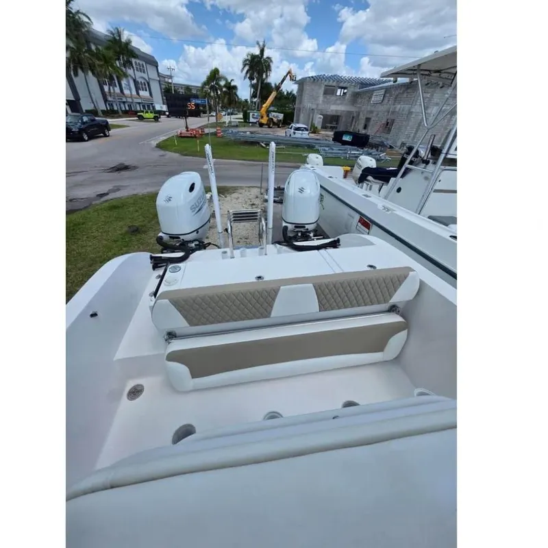 Slide: The Image of 2023 Twin Vee 240 GFX CC boat with dual Suzuki outboard motors, docked outdoors. - 7