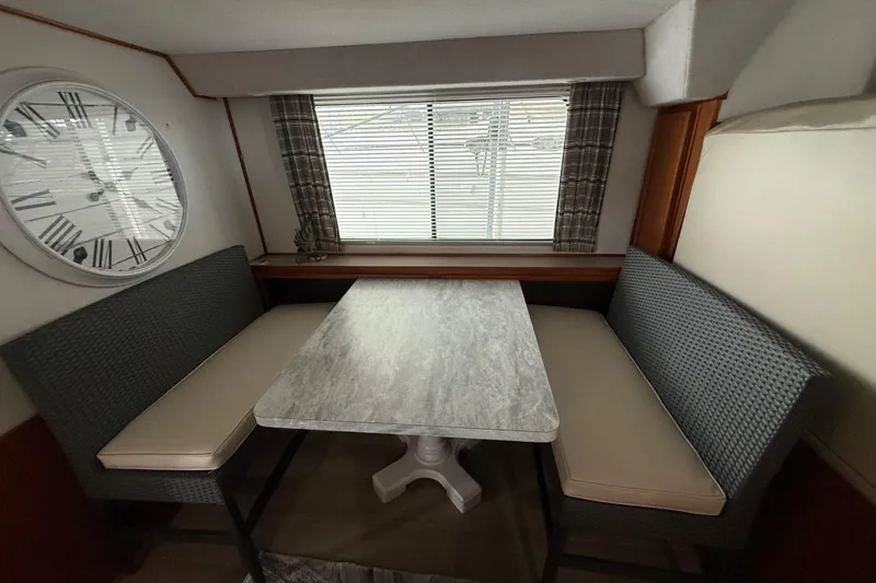 Slide: The Image of Interior of 1995 Harbor Master 52 Wide Body with dining area and large wall clock. - 13