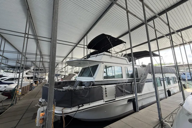 Slide: The Image of 1995 Harbor Master 52 Wide Body yacht docked in a covered marina. - 2