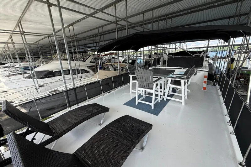 Slide: The Image of 1995 Harbor Master 52 Wide Body yacht with spacious deck and seating area in marina. - 6