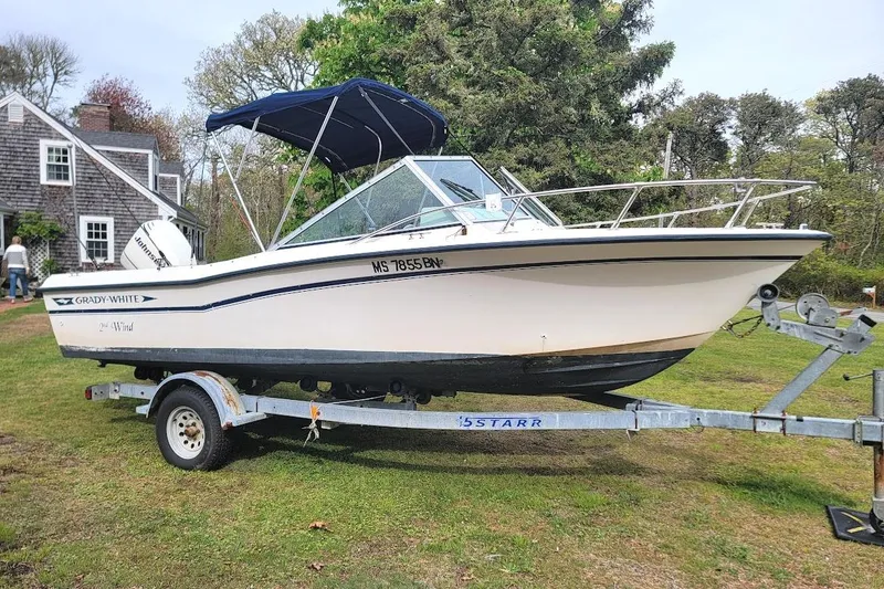 The Image of 1988 Grady-White Freedom 192 boat on trailer, parked on grass near a house. - 0