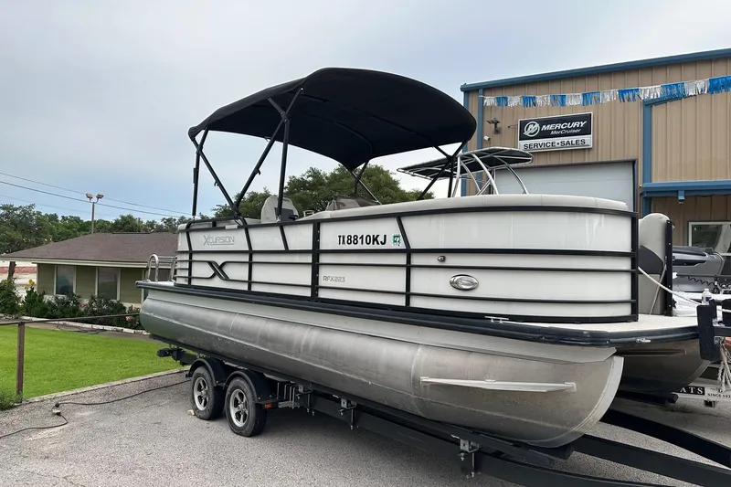 The Image of 2021 Xcursion 223 RFX pontoon boat on trailer at dealership. - 0