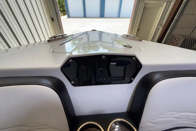 Slide: The Image of 2024 Sunsation 32 CCX boat dashboard with Fusion audio system in a storage facility. - 12