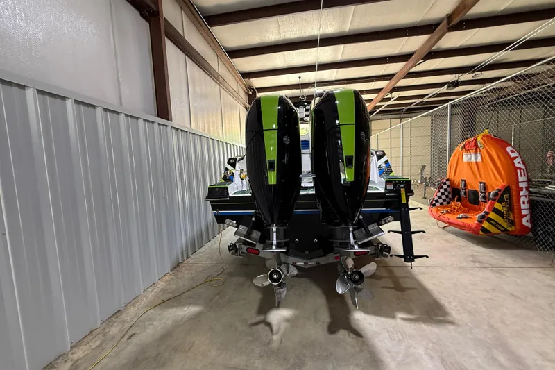 Slide: The Image of 2024 Sunsation 32 CCX boat with dual engines in a storage facility. - 2