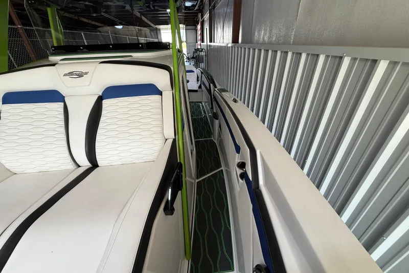 Slide: The Image of 2024 Sunsation 32 CCX boat interior with white and blue seating, sleek design. - 8