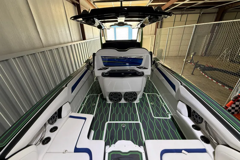 Slide: The Image of 2024 Sunsation 32 CCX boat interior with modern seating and sleek design in a storage facility. - 9