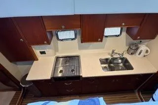 Slide: The Image of 2006 Endeavour 44 TrawlerCat kitchen with stove, sink, and wooden cabinets. - 13