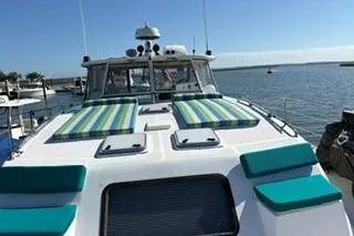 Slide: The Image of 2006 Endeavour 44 TrawlerCat with striped deck cushions, docked in a sunny marina. - 6