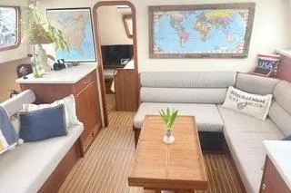 Slide: The Image of Interior of 2006 Endeavour 44 TrawlerCat with cozy seating and world map decor. - 8