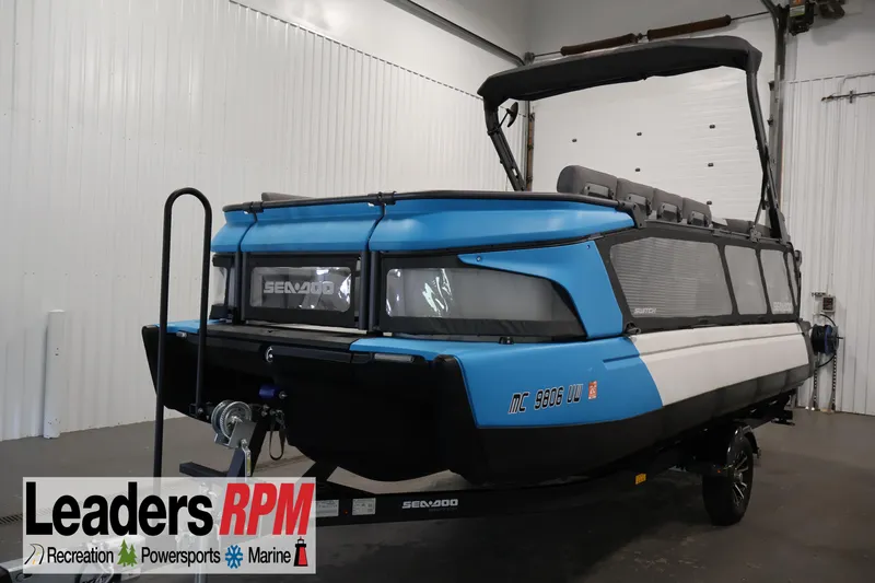 The Image of 2023 Sea-Doo Switch Cruise 21 pontoon boat in showroom, featuring blue and white design. - 1