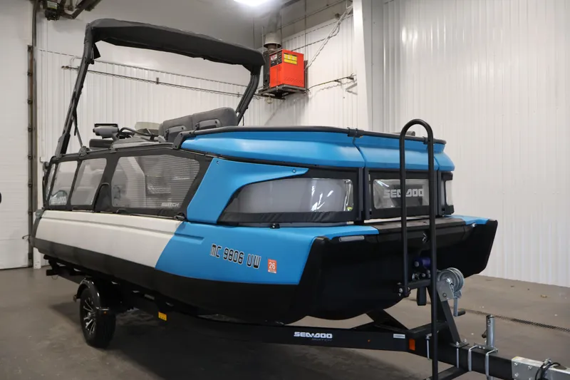 Slide: The Image of 2023 Sea-Doo Switch Cruise 21 pontoon boat in a garage setting. - 3