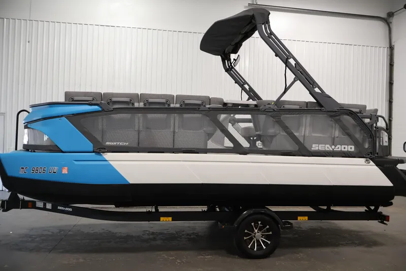 Slide: The Image of 2023 Sea-Doo Switch Cruise 21 pontoon boat in a showroom, side view. - 8