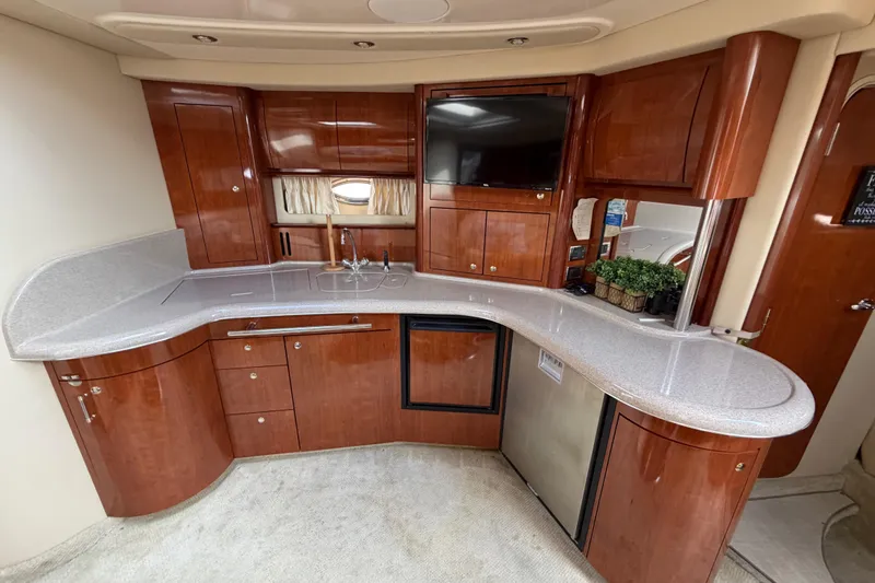 Slide: The Image of Luxurious 2003 Sea Ray 420 Sundancer yacht interior with elegant wood cabinetry and modern amenities. - 16