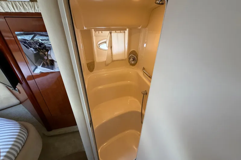 Slide: The Image of Interior shower of 2003 Sea Ray 420 Sundancer yacht, featuring compact design and porthole window. - 24