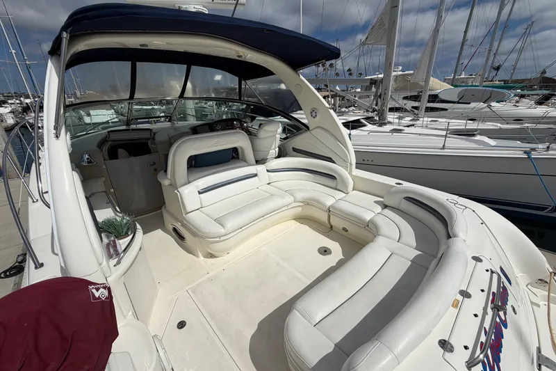 Slide: The Image of 2003 Sea Ray 420 Sundancer yacht with spacious white seating and marina backdrop. - 4