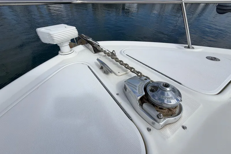Slide: The Image of Anchor windlass on 2003 Sea Ray 420 Sundancer yacht, docked on calm water. - 40