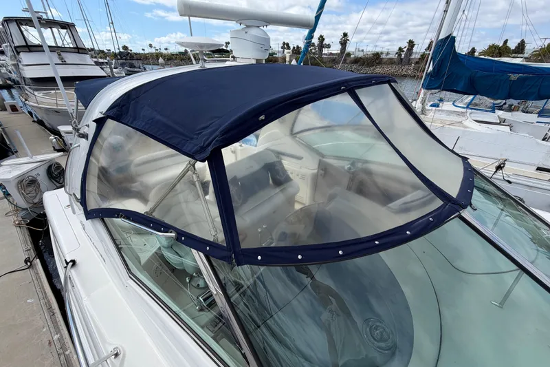Slide: The Image of 2003 Sea Ray 420 Sundancer yacht with blue canopy docked at marina. - 45