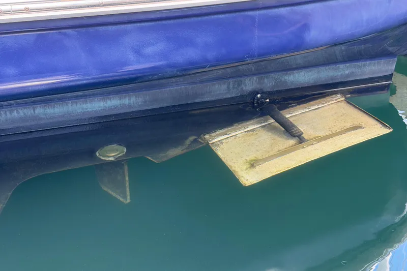 Slide: The Image of 2003 Sea Ray 420 Sundancer boat hull and trim tab in water. - 48